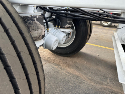 Bottom-dump trailer wheel hub area showing multiple air ride components and suspension lines.