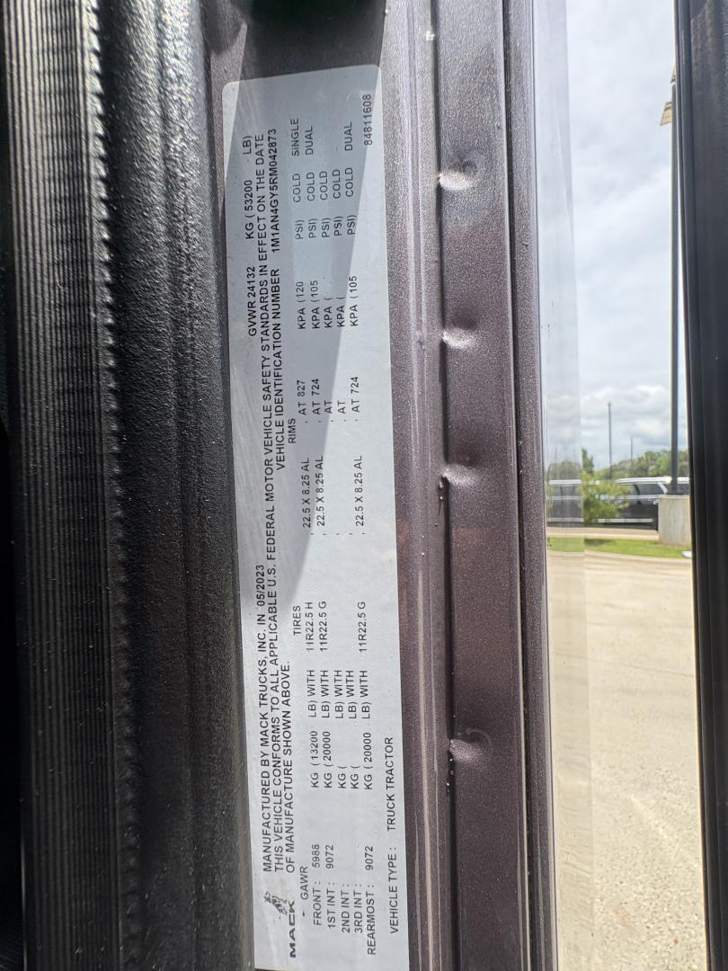 Mack AN64T70 truck VIN label on door jamb with detailed specs including manufacturer details and weights.