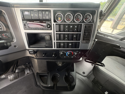 Truck cab dashboard of a 2024 Mack AN64T70 showing gauges, switches, and controls in front of steering area.