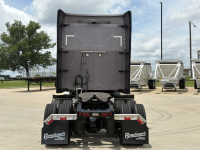 Mack AN64T70 tractor with rear view showing fifth wheel and dual rear axles, cab back door open, trailer hitch components visible.