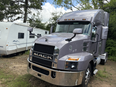 Mack AN64T70 conventional sleeper truck showing front grille with Mack emblem and chrome bumper, side mirrors, and headlights.