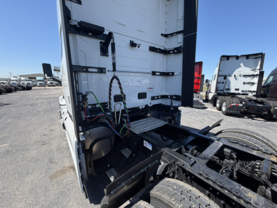 Truck cab area of a 2027 Mack PR64T76H showing rear sleeper section and chassis with wiring harnesses, step plate, and hydraulic lines.