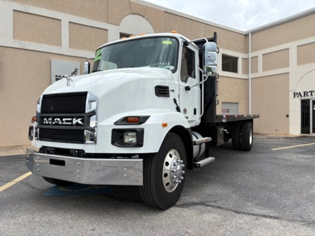 Mack MD6 flatbed truck showing front grille with Mack logo and headlights.