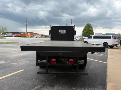 Flatbed truck bed rear view with black platform and taillights, Mack MD6 listing. Visible text on rear shows 'Brandon' and 'Frontier' brand stickers on left and right of undercarriage.