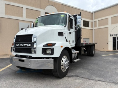 Mack MD6 flatbed truck showing front grille with Mack logo and headlights.