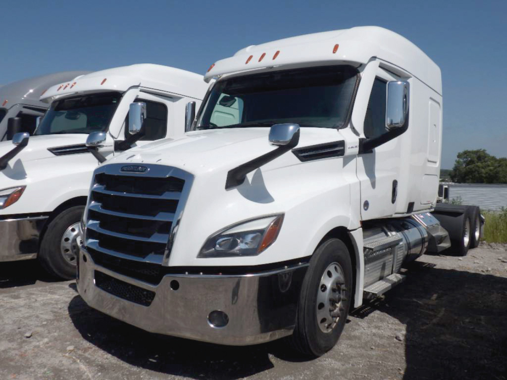 Truck engine bay/cab of a white 2024 Freightliner Cascadia 126 conventional sleeper showing front grille and side mirrors.