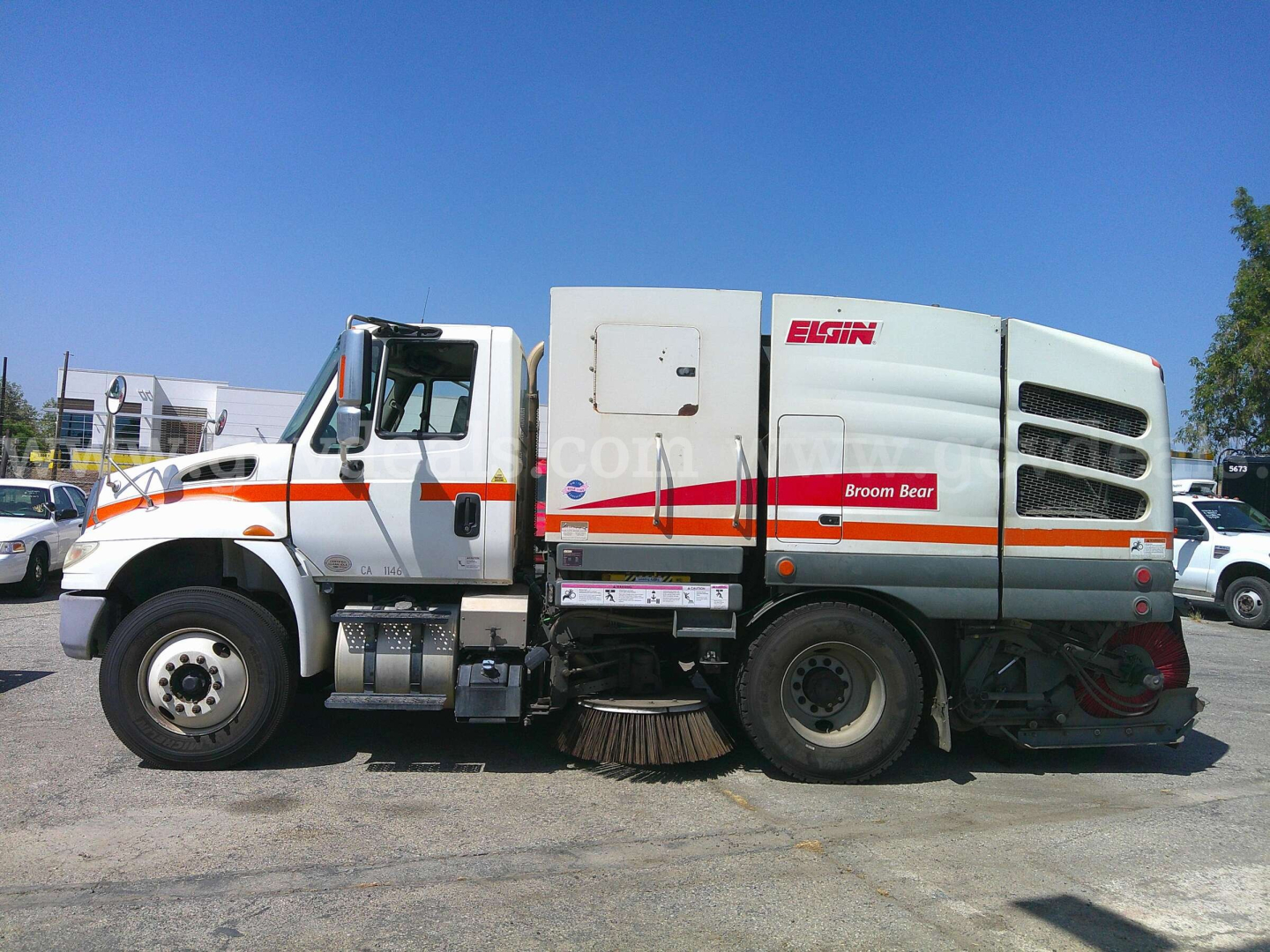 2017 International DuraStar 4400 street sweeper side view showing Elgin Broom Bear body and sweeping brushes, cab with orange stripe, stock number 25530-1304.