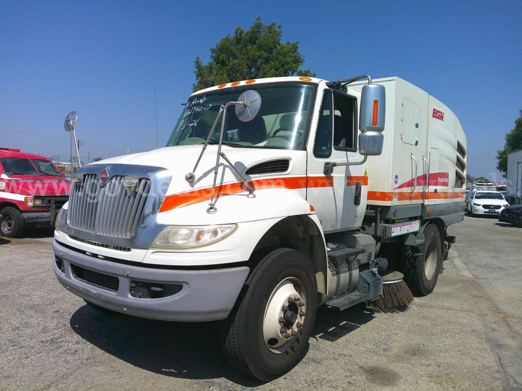 DuraStar 4400 street sweeper truck with white and orange livery, front grille, side cabinet, and sweeping brushes visible under the cab.