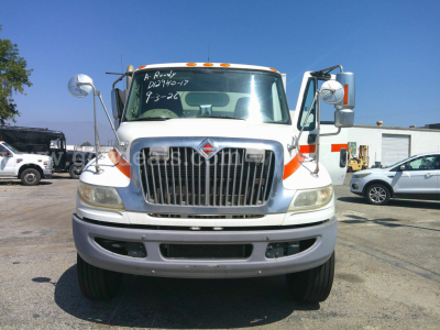 International DuraStar 4400 sweeper truck front view showing grille and mirrors with writing on windshield.