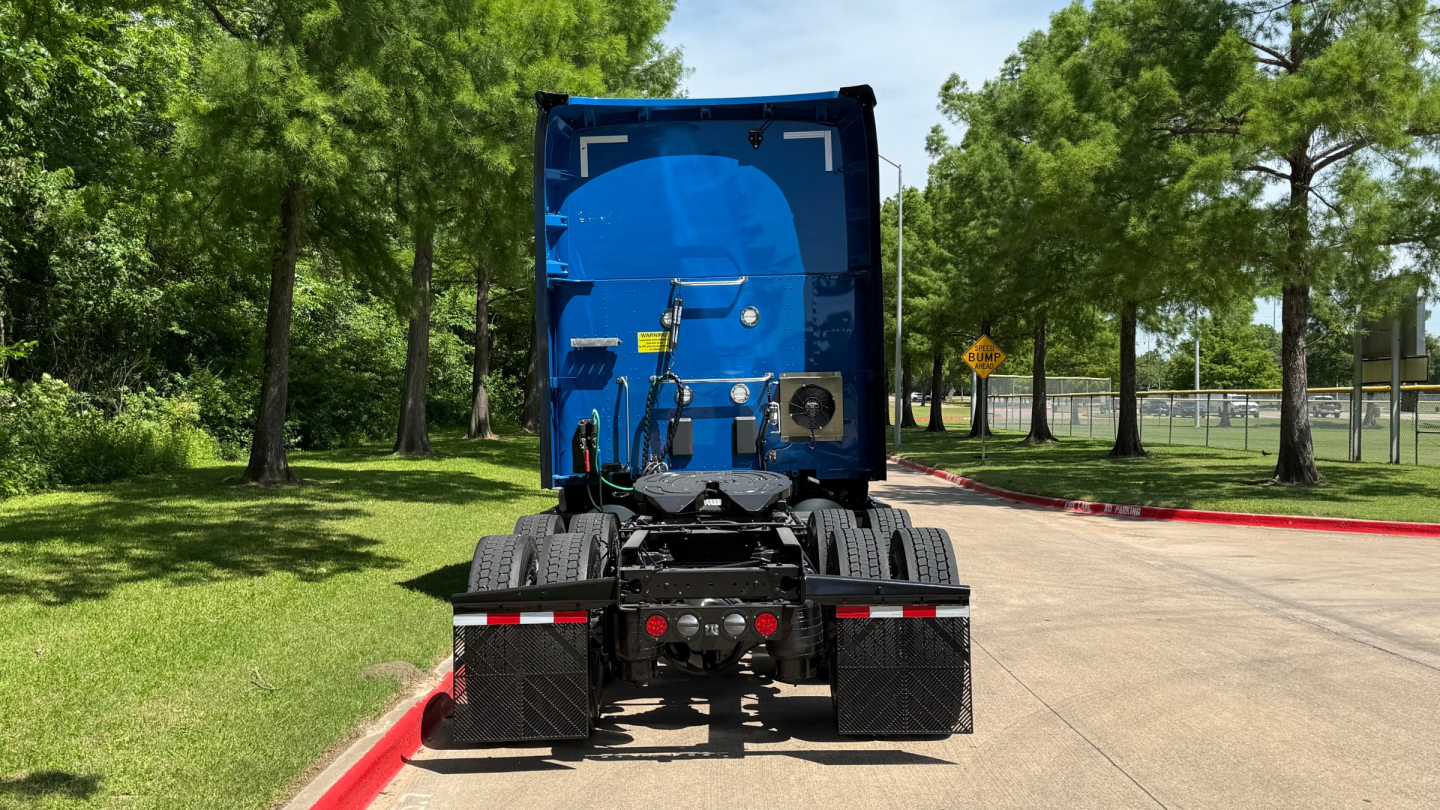 Kenworth T680 rear view showing truck chassis and dual rear axles in a park area