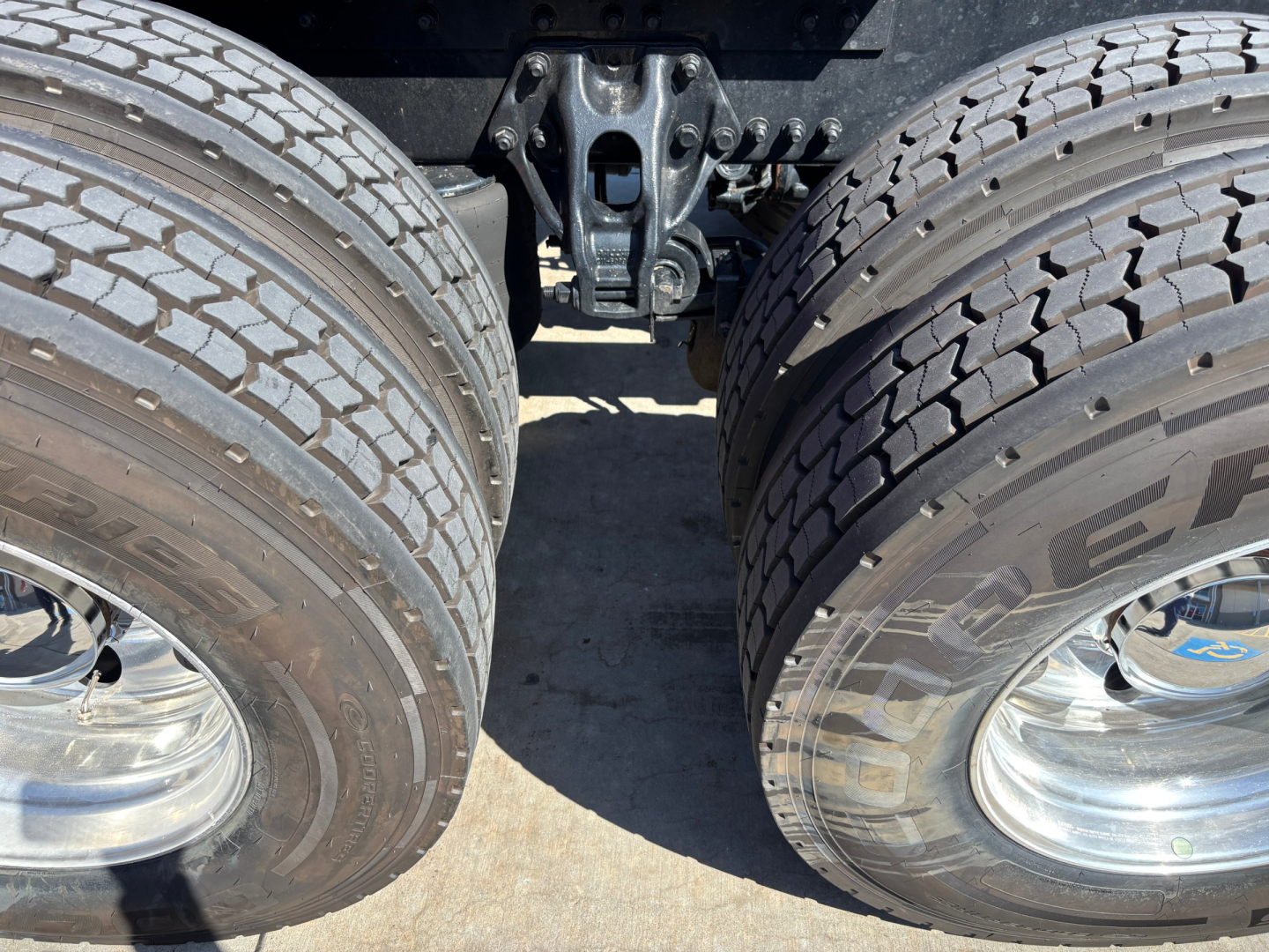 Rear view of a Kenworth T680 truck chassis showing dual rear axles and tires with steel rims.