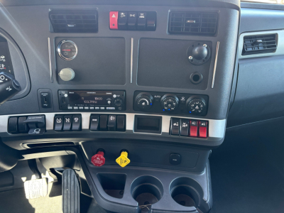 Kenworth T680 dash area showing dashboard controls and ignition area with multiple switches and gauges.