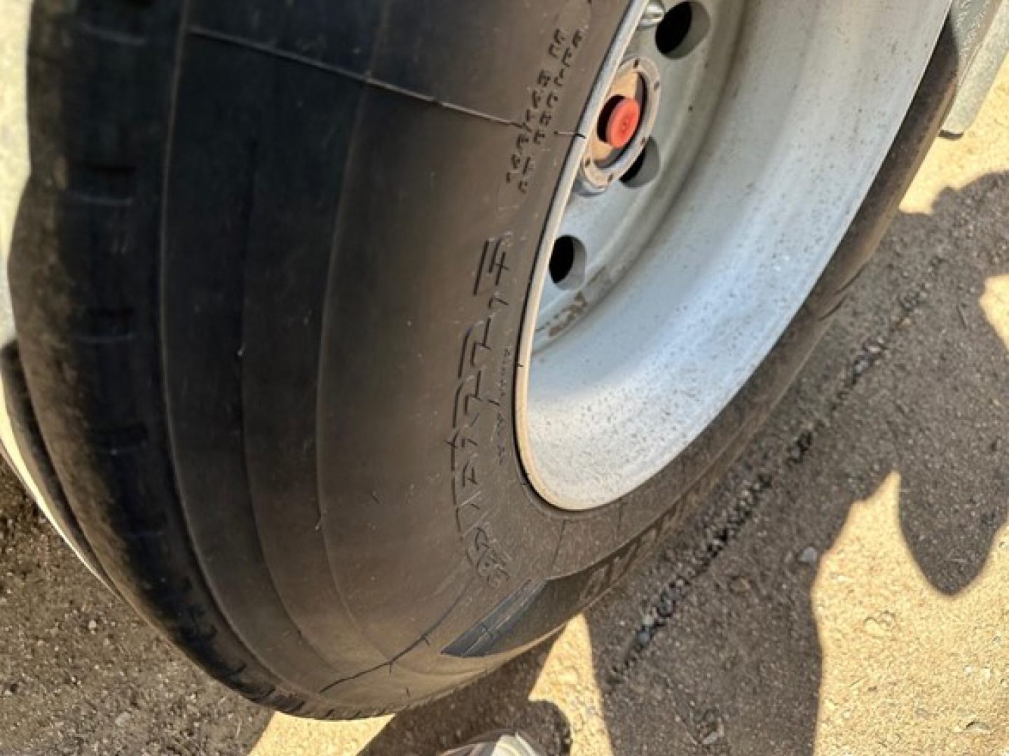 Tire sidewall of a Timpte hopper trailer showing smooth rubber tread and wheel hub with red center cap