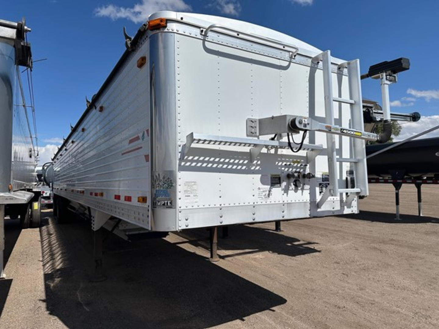 Timpte Super Hopper trailer rear view showing loading chute, rear ladder, and reflective markings.