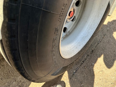 Tire sidewall of a Timpte hopper trailer showing smooth rubber tread and wheel hub with red center cap
