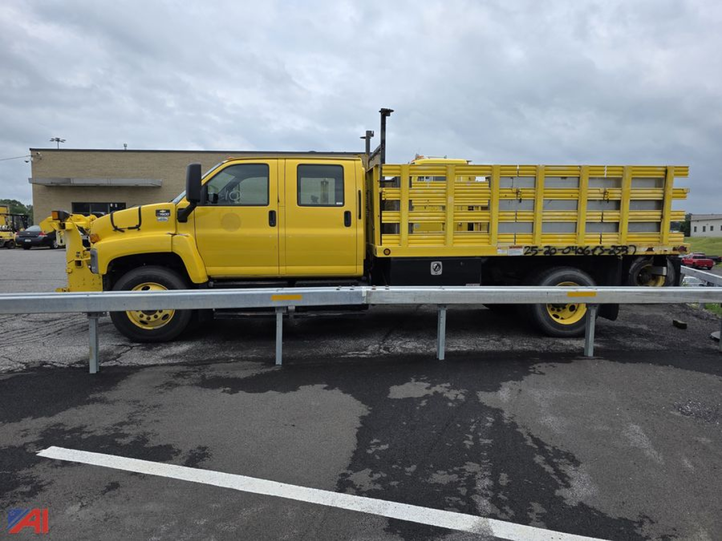 Yellow 2008 Chevrolet Kodiak C7500 stake truck side view showing cargo bed with wooden rails and hydraulic hoist.