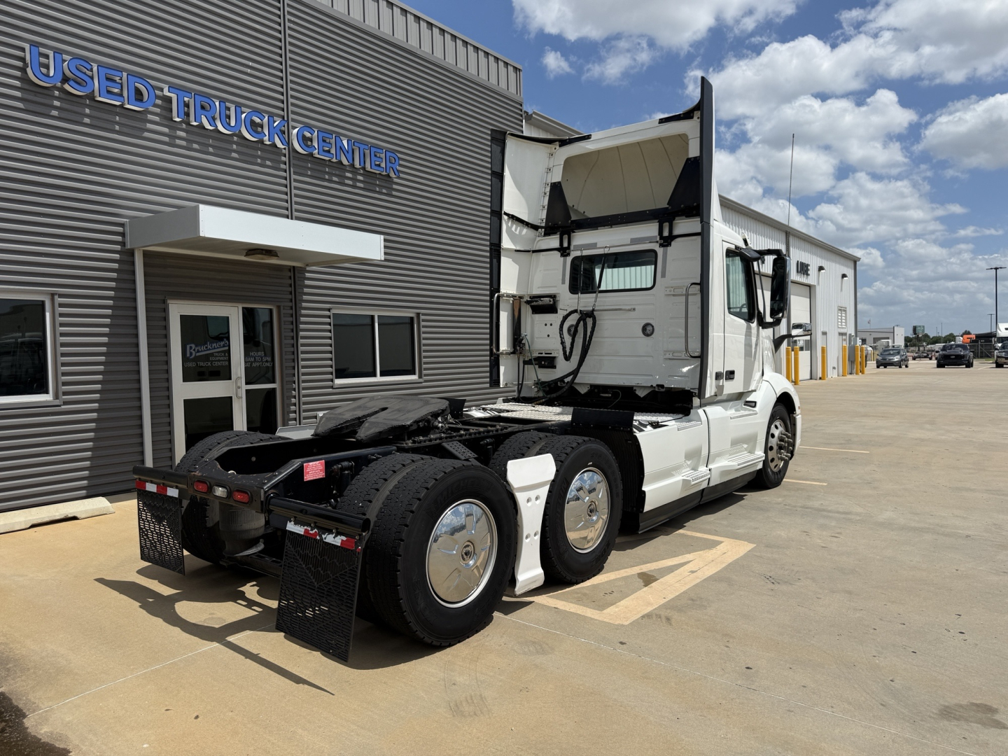Volvo VNL300 2019 truck in service condition parked beside a building with 'USED TRUCK CENTER' sign.