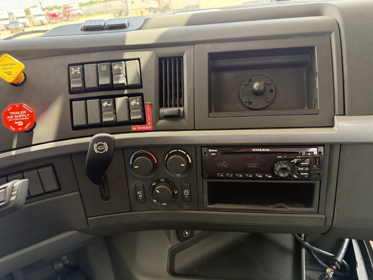 Volvo VNL300 dashboard and control panel showing climate controls, radio, and switches in a truck cab interior.
