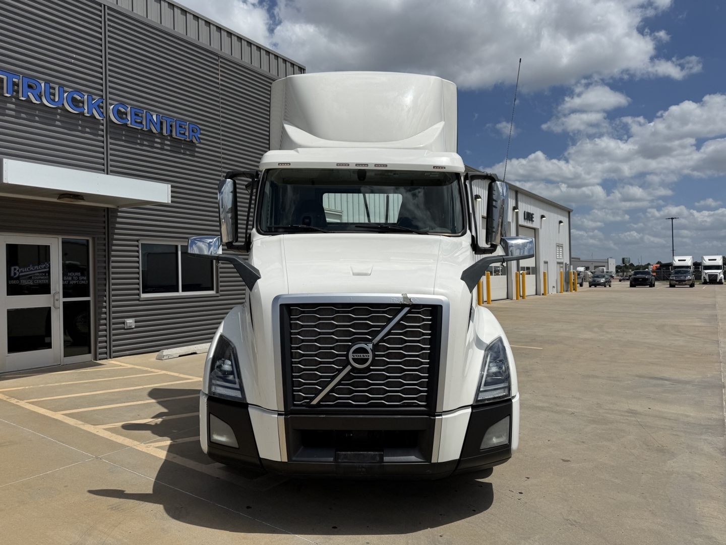 Volvo VNL300 daycab truck front view showing large grille and headlights in service environment