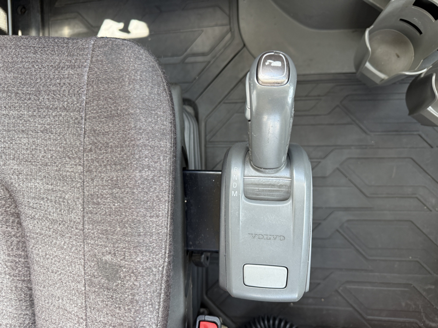 Volvo VNL300 interior gear selector shows automatic transmission shifter in view with floor mat and steering wheel area.