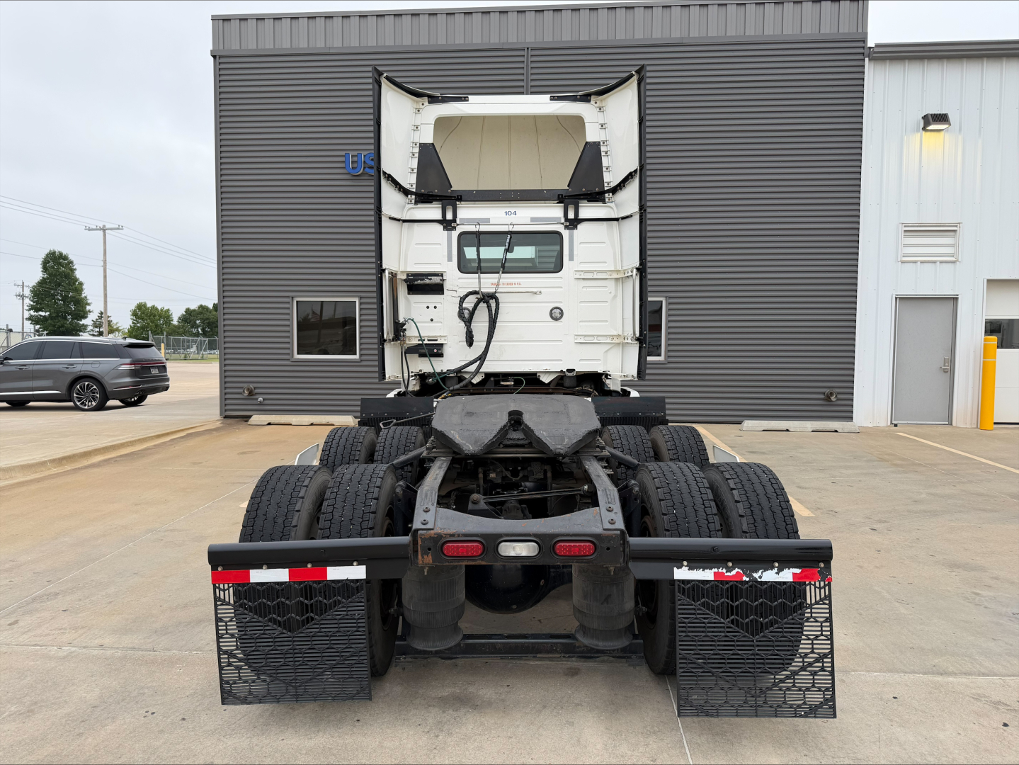 Rear view of a 2019 Volvo VNL300 highway tractor with dual rear axles, fifth wheel, and mud flaps; no visible text on the chassis.