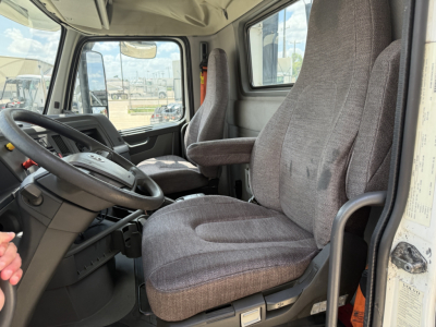 Volvo VNL300 cab interior showing driver's seat and passenger seat with steering wheel and dashboard visible.