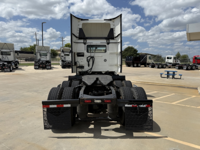 Volvo traditional cab truck chassis rear view showing dual rear axles and fifth-wheel mounting in a truck lot.
