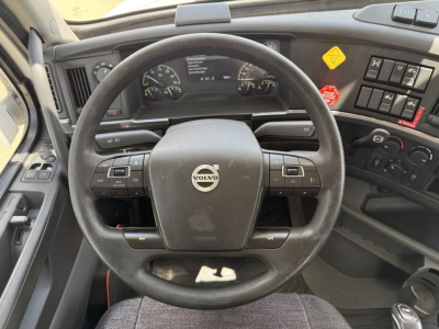 Volvo VNL300 truck interior showing steering wheel, dashboard gauges, and control panel with buttons and knobs.