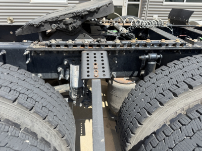 Volvo VNL300 truck chassis showing dual rear axles and fifth-wheel mounting plate with various cables and frame hardware.