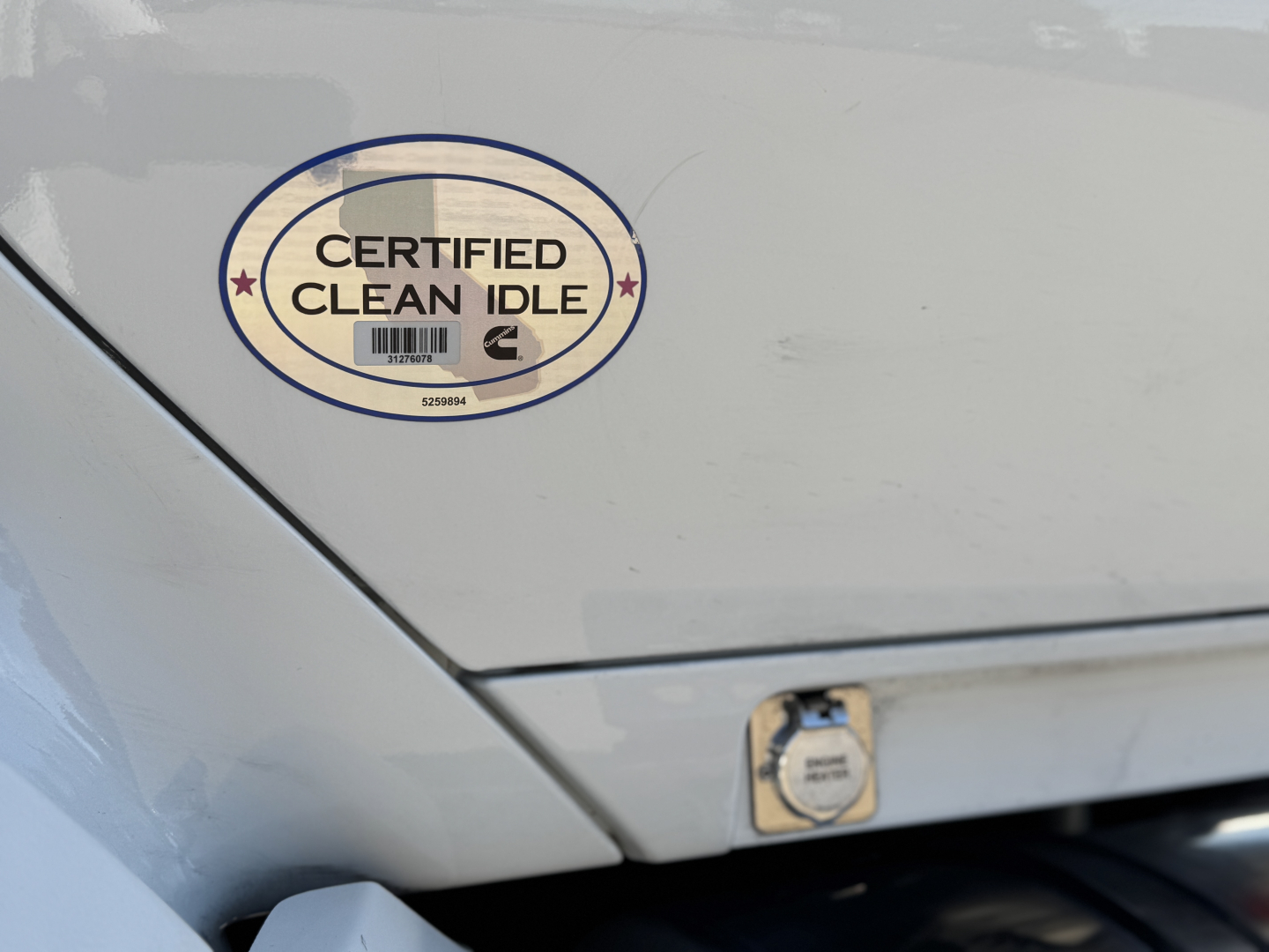 Sticker on Kenworth T680 showing Certified Clean Idle badge and fuel cap area.