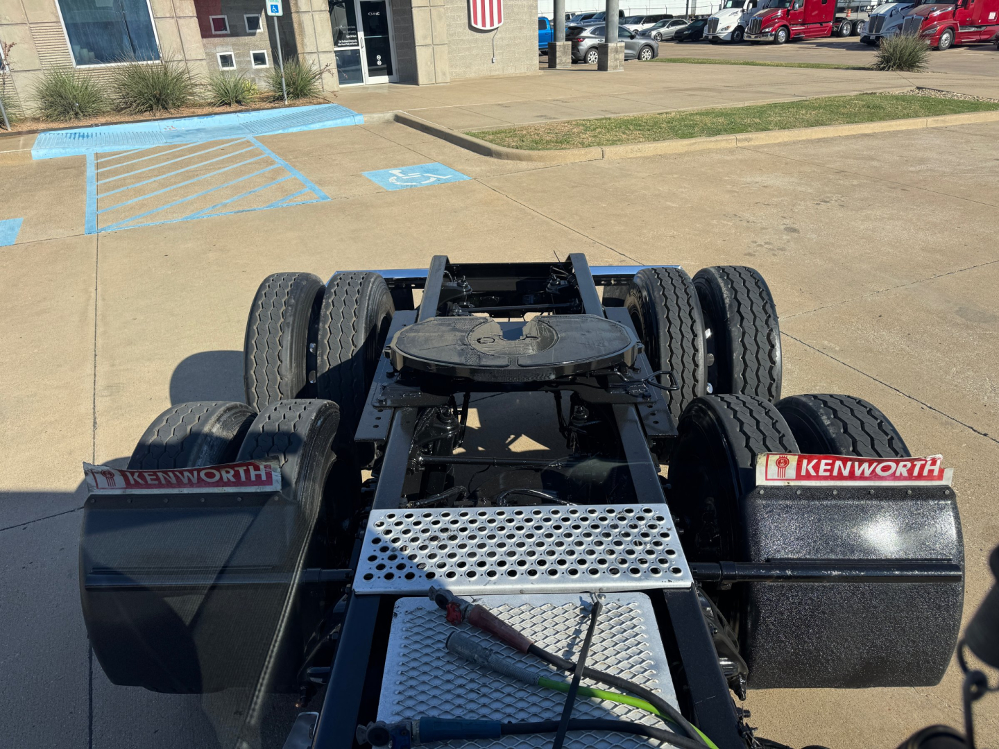 Kenworth T680 chassis and rear view showing dual rear axles, fifth wheel plate, and Kenworth mud flaps.