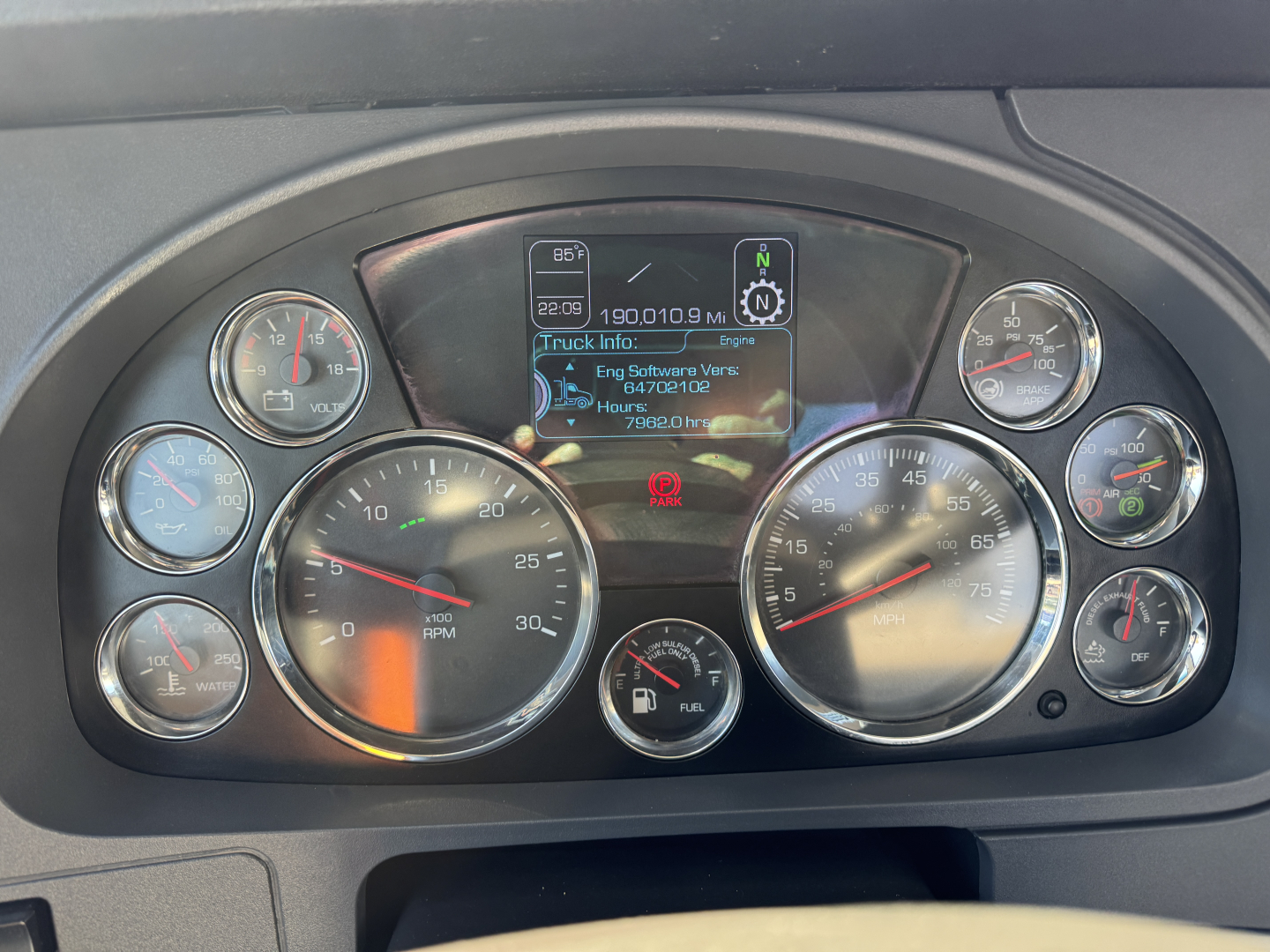 Kenworth T680 instrument cluster with multiple gauges and center display showing truck info.