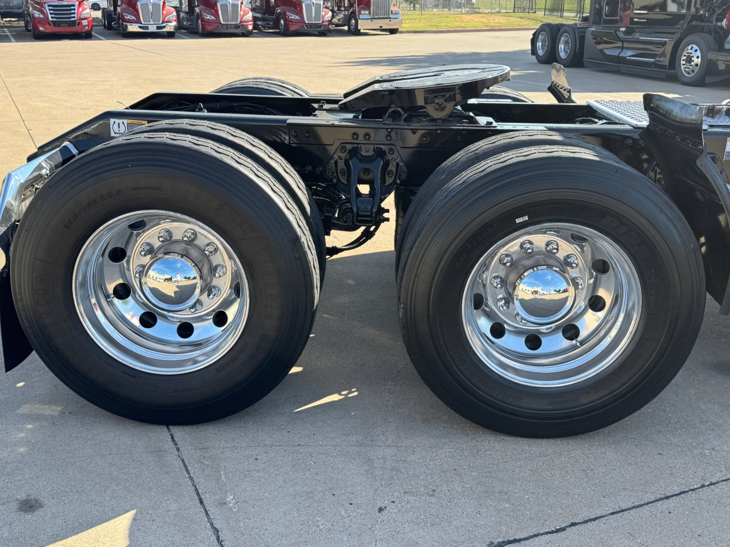 Kenworth T680 truck rear axle dual wheels showing chrome wheels and suspension frame.