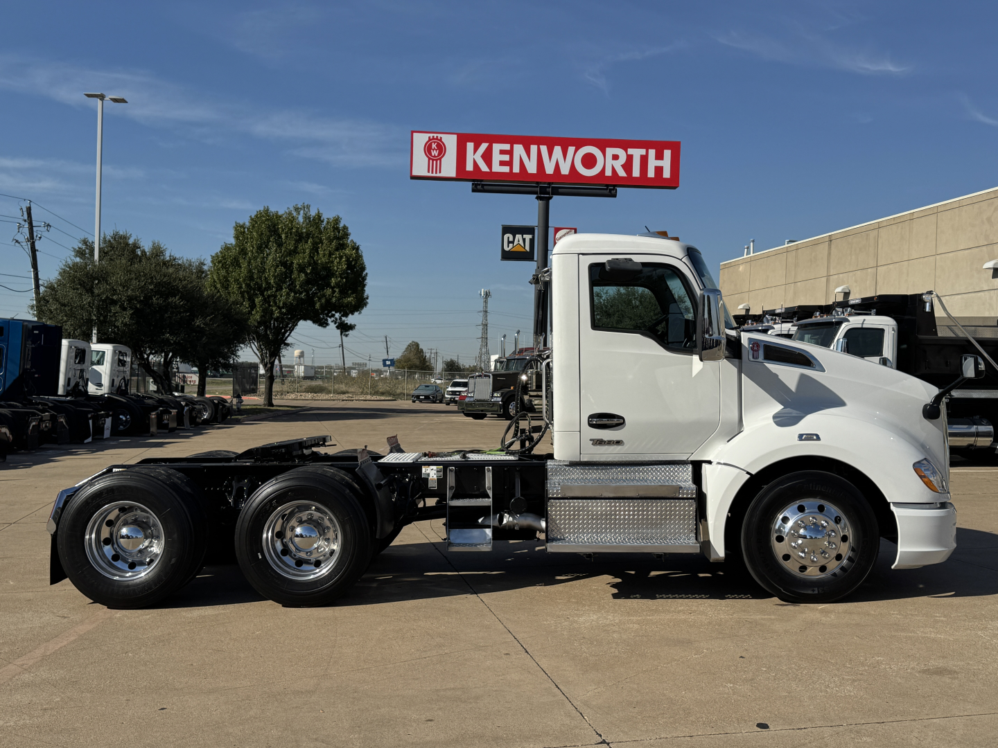 Kenworth T680 tractor side view showing 3-axle chassis and aluminum fuel tanks