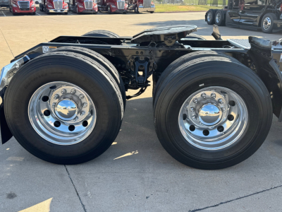 Kenworth T680 truck rear axle dual wheels showing chrome wheels and suspension frame.