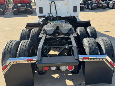 Kenworth T680 chassis and rear drivetrain showing dual rear axles and mud flaps, viewed from behind.