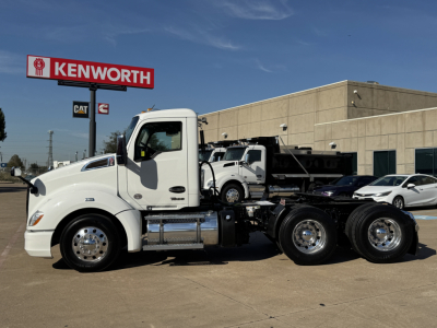 Kenworth T680 conventional daycab truck side view showing white cab and chassis with tanks and dual rear axles.