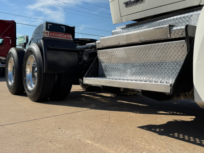 Kenworth T680 truck rear/side view showing chrome diamond plate toolbox, dual rear wheels, and wheel wells.