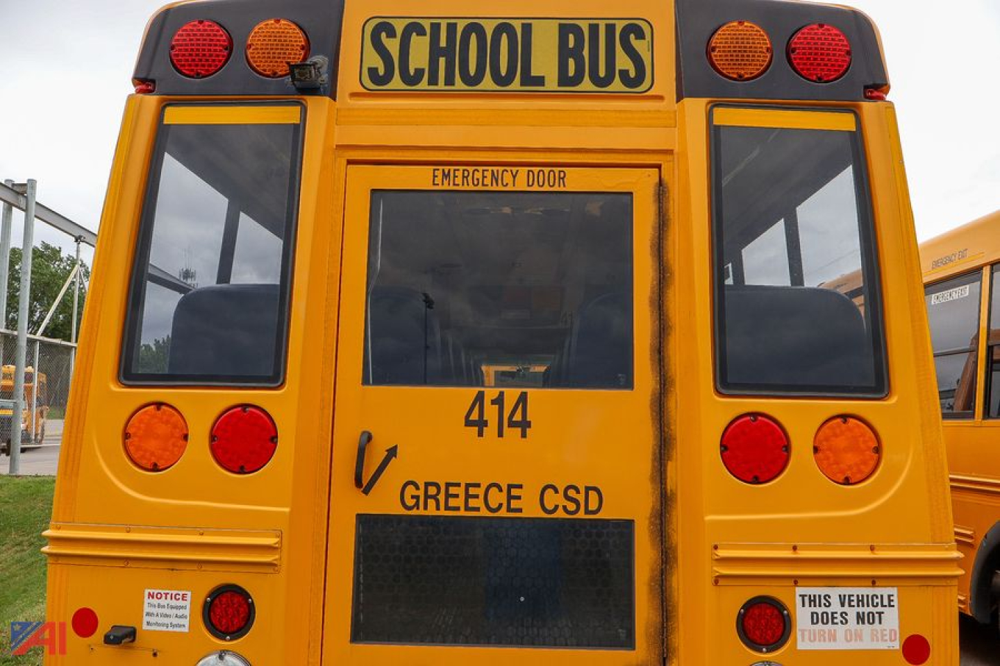 Rear view of a 2019 Ford Blue Bird E-Series school bus showing emergency door, route 414, and Greece CSD lettering.