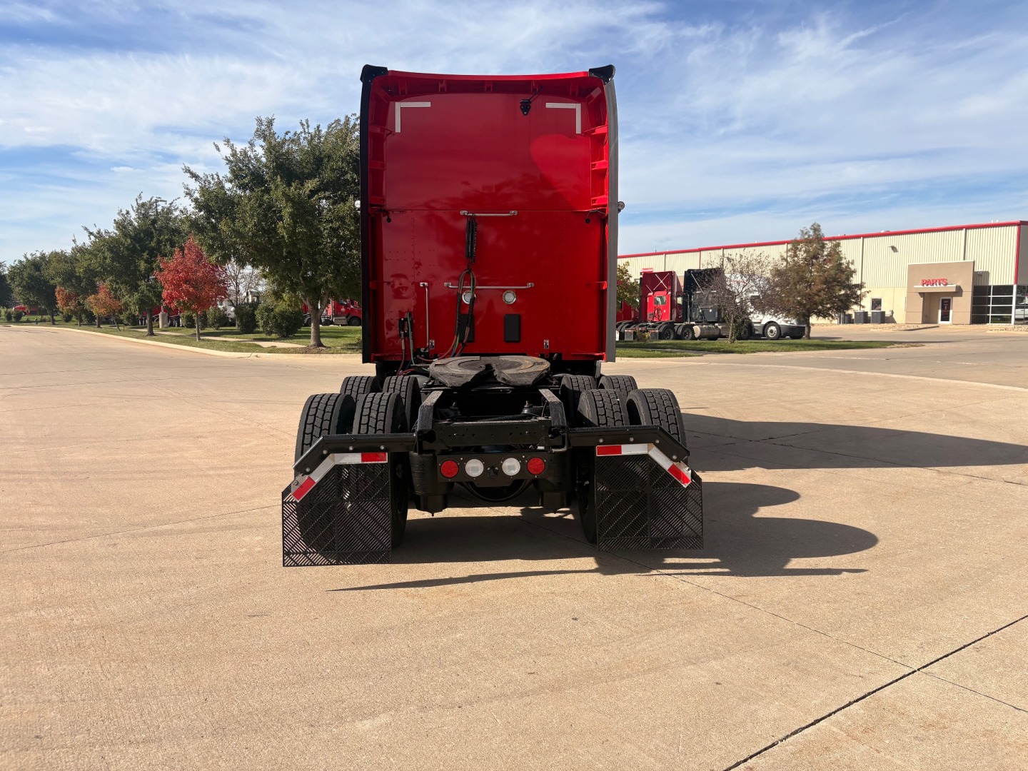 Kenworth T680 rear view showing tractor cab and dual rear axles with mud flaps.