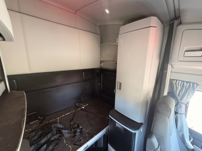 Kenworth T680 cab interior showing sleeper area and storage cabinet visible, with seat and partition panels.