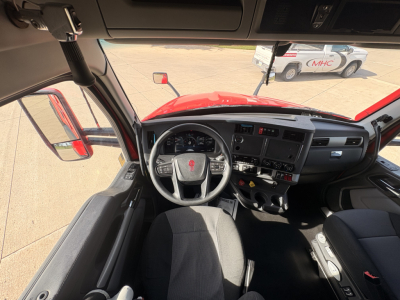 Kenworth T680 interior cab dashboard and steering wheel view from driver seat showing controls and gauges.