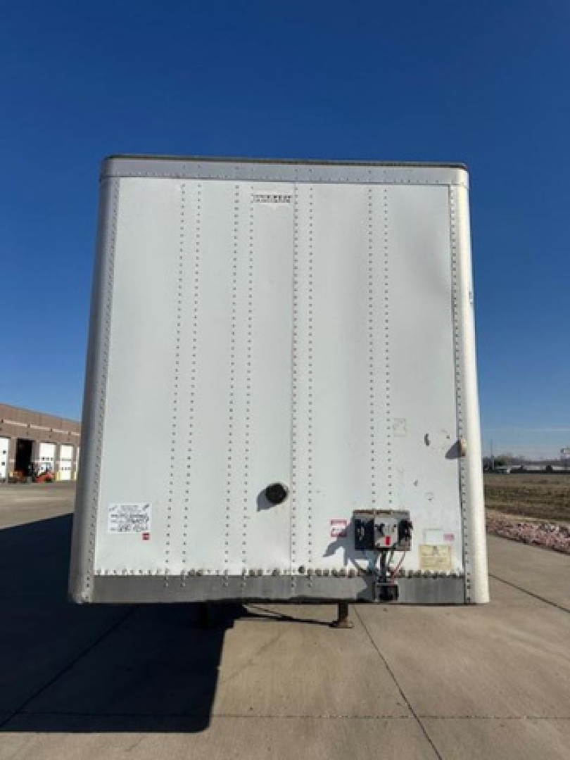 Rear view of a white 2013 Wabash van trailer with a gooseneck connector and safety decals visible at the bottom edge.