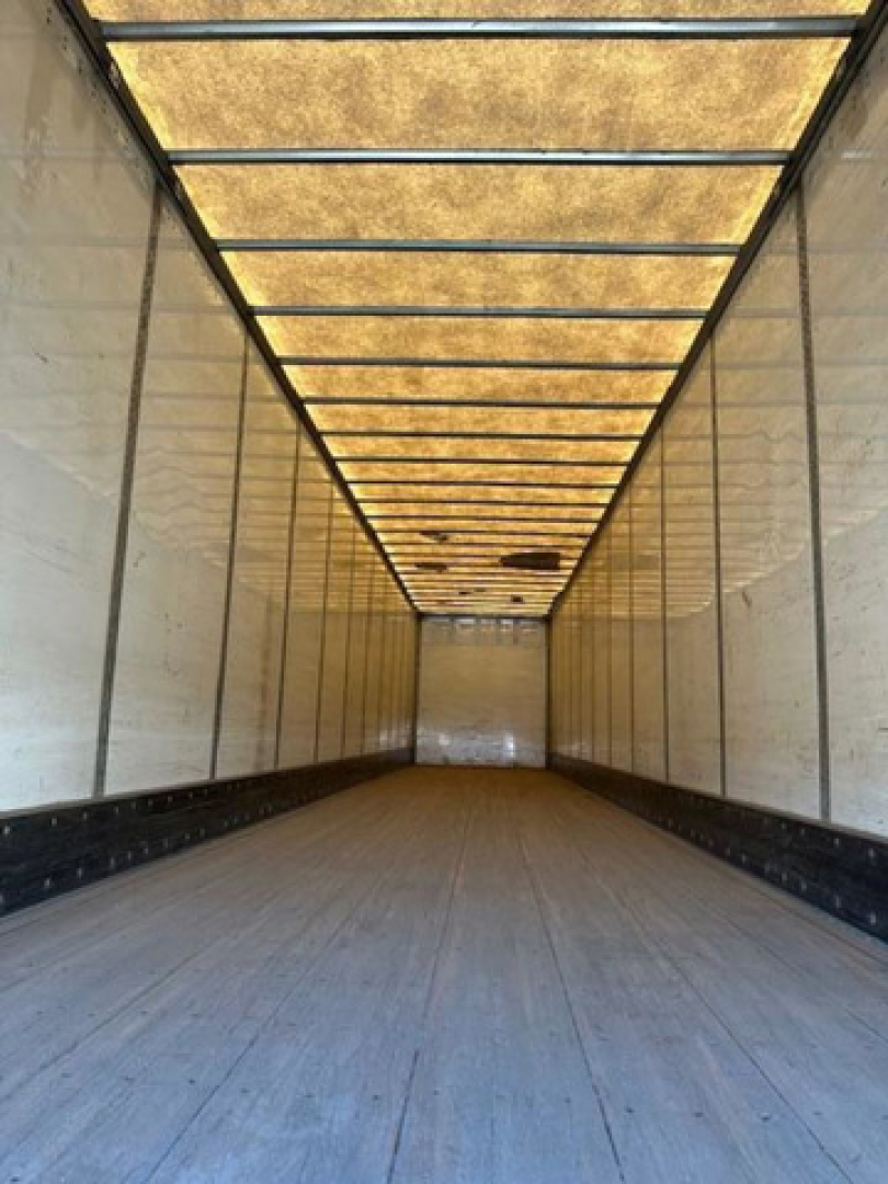 Trailer interior showing empty van trailer cargo area with wooden floor and side walls
