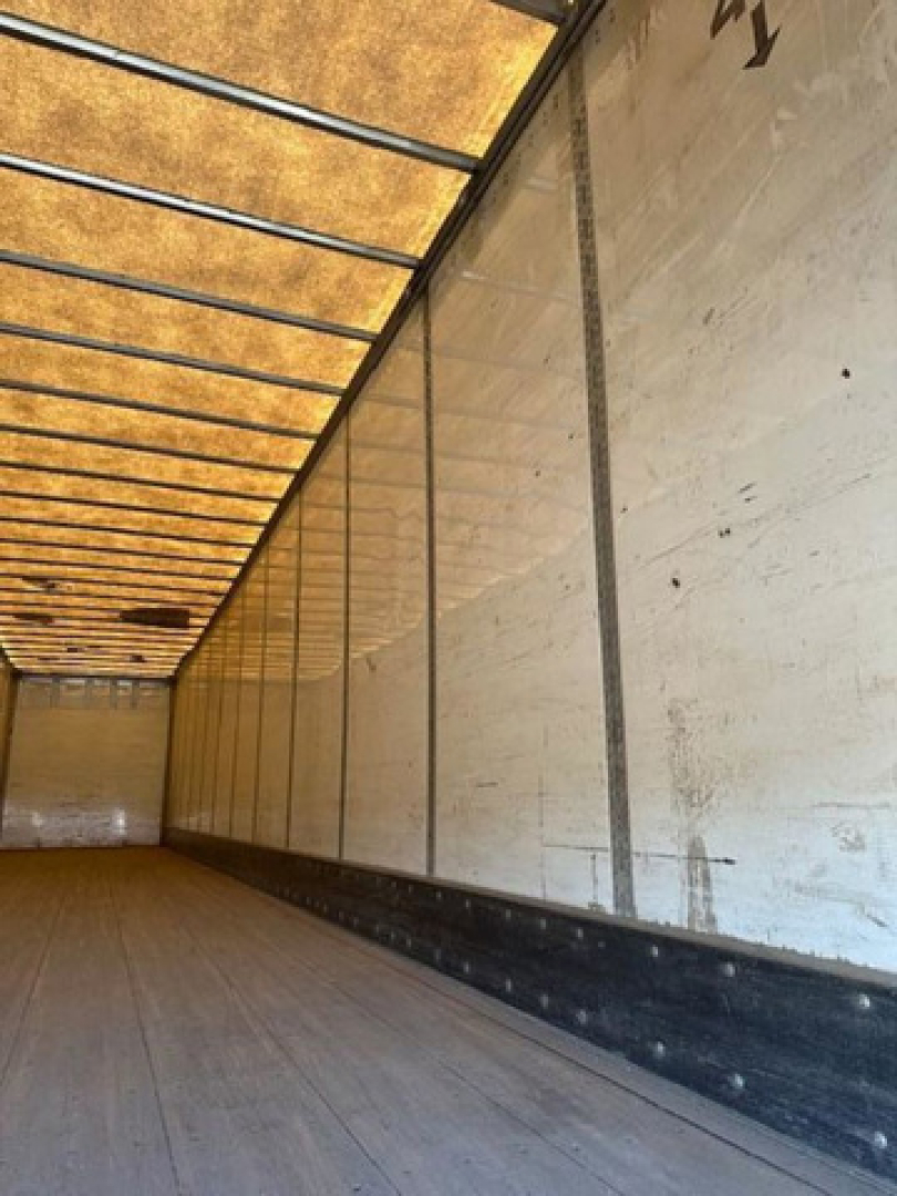 Interior of a Wabash van trailer with wooden floor and metal side walls; long empty cargo area.
