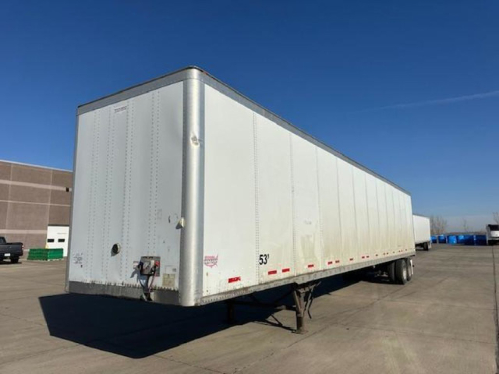 Side view of a white Wabash dry van trailer with 53' length, tandem axles, and safety markings along the lower side. Front corner has hitch and access door handles not visible.