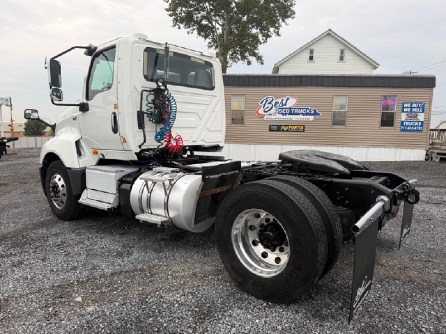 Used 2018 International LT625 conventional daycab truck in front of a dealership, showing the cab, fuel tanks, wheel, and chassis. VIN tag and stock number not visible on the image.