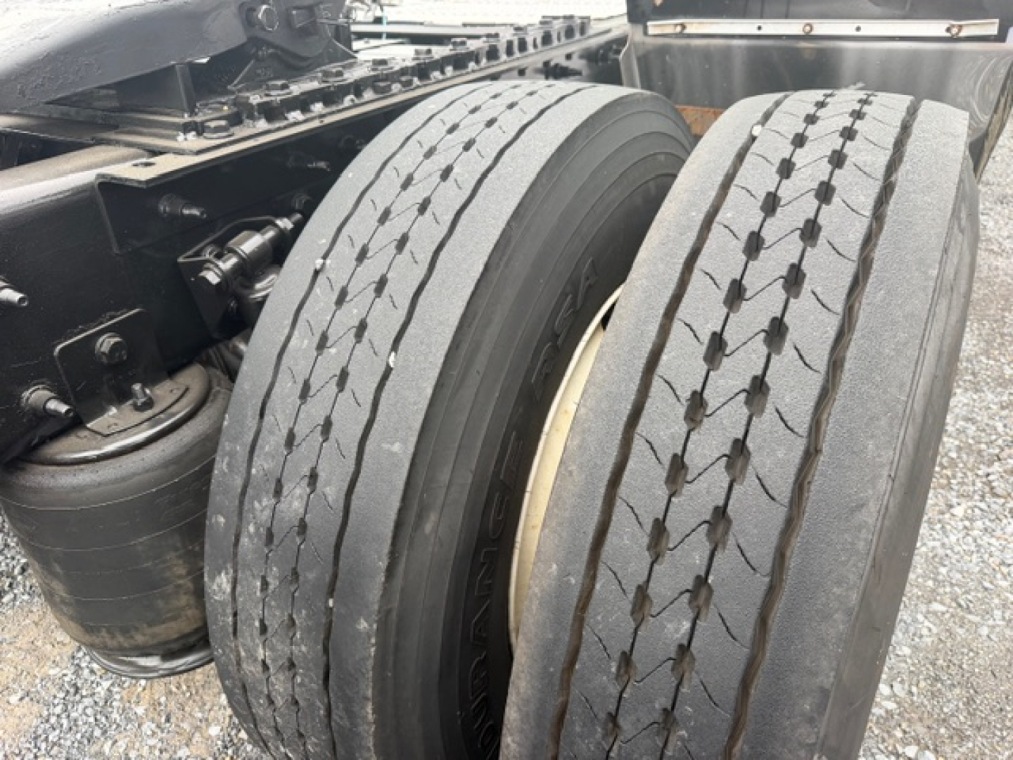 Dual rear truck tires with rims and surrounding chassis; no readable label text visible on tires or nearby components.