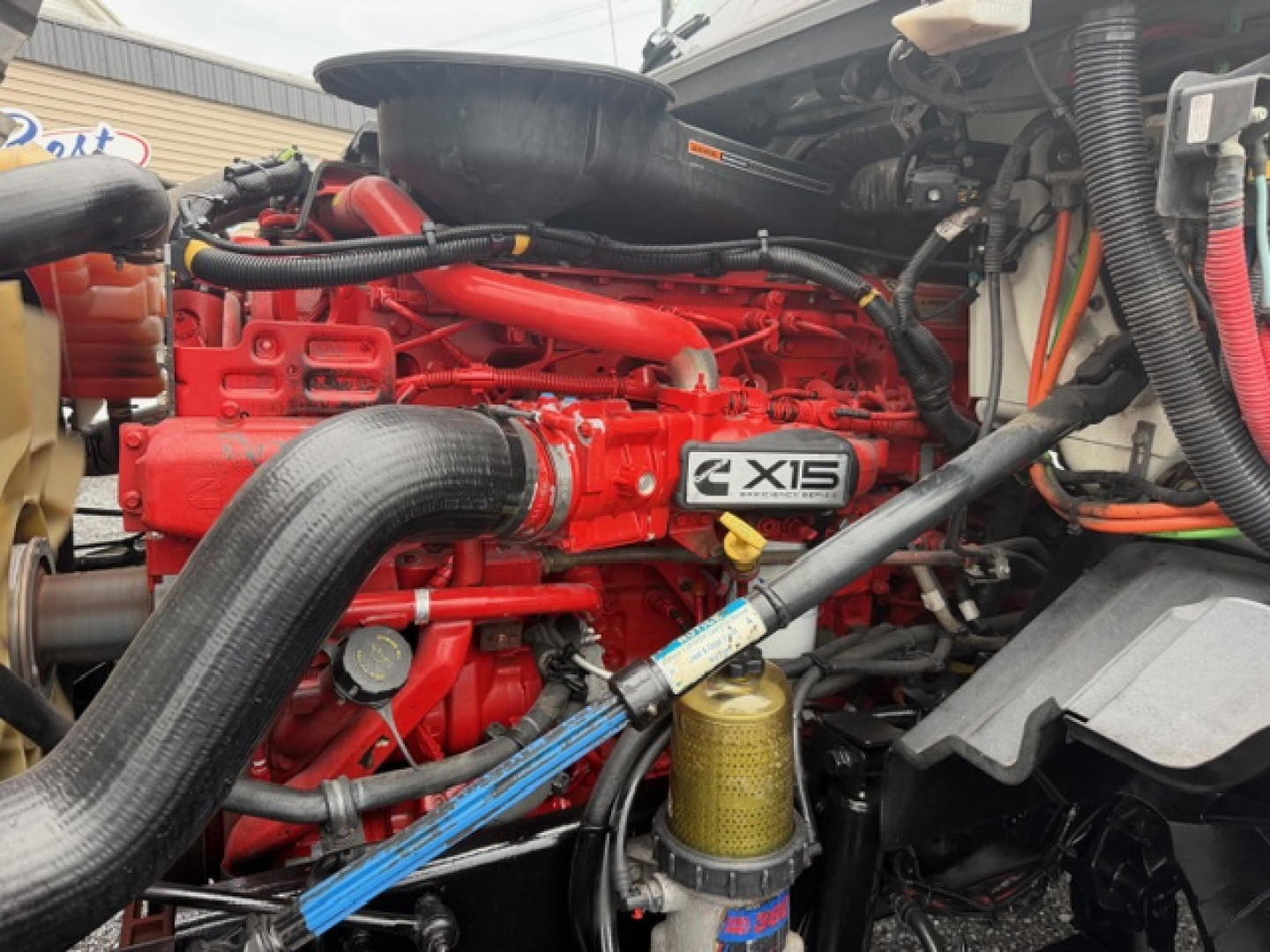 International LT625 engine bay showing red engine with IXIS badge and surrounding hoses and components.