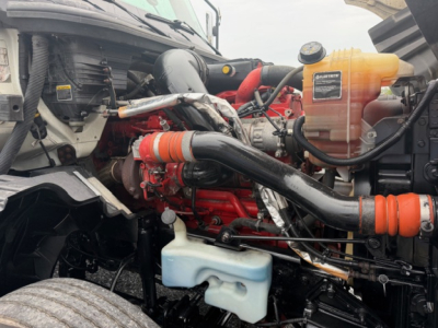 Truck engine bay showing LT625 engine with orange coolant reservoir, blue windshield washer reservoir, and black intake piping.
